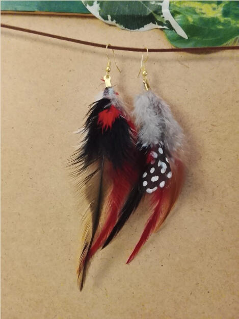 Pendientes artesanales Fuego Silente con plumas rojas, negras y grises en composición intensa y equilibrada