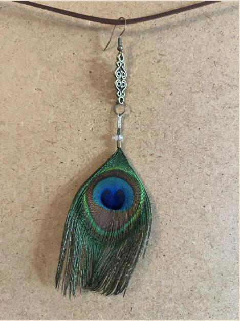 Pendiente artesanal Ojo del Bosque con pluma verde y centro azul intenso de inspiración natural